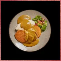 Wagamama Chicken Katsu Curry — crispy breaded chicken served with Japanese curry sauce, steamed rice, and fresh salad garnish.
